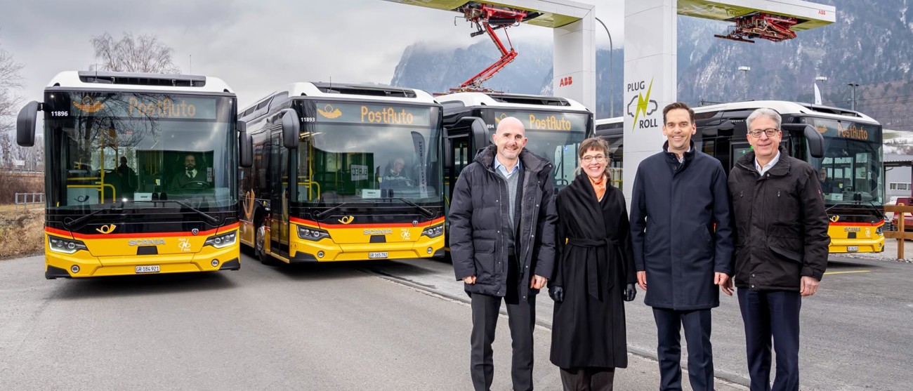 Plug’n Roll-Ladestation mit den ersten Elektropostautos für Graubünden und Vertreter:innen vor Ort.