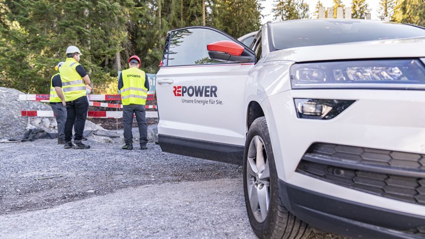 Repower-Team an einer Baustelle; Firmenfahrzeug steht daneben, Mitarbeitende tragen Sicherheitswesten.